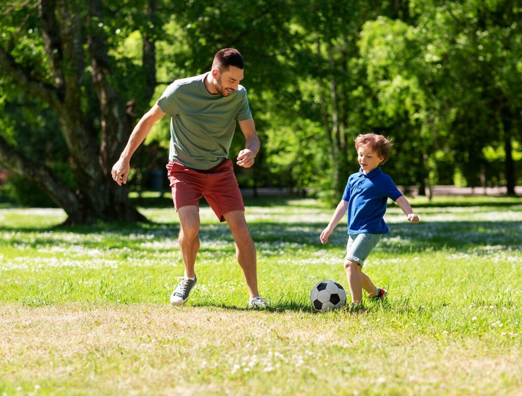 Dad and kid playing football